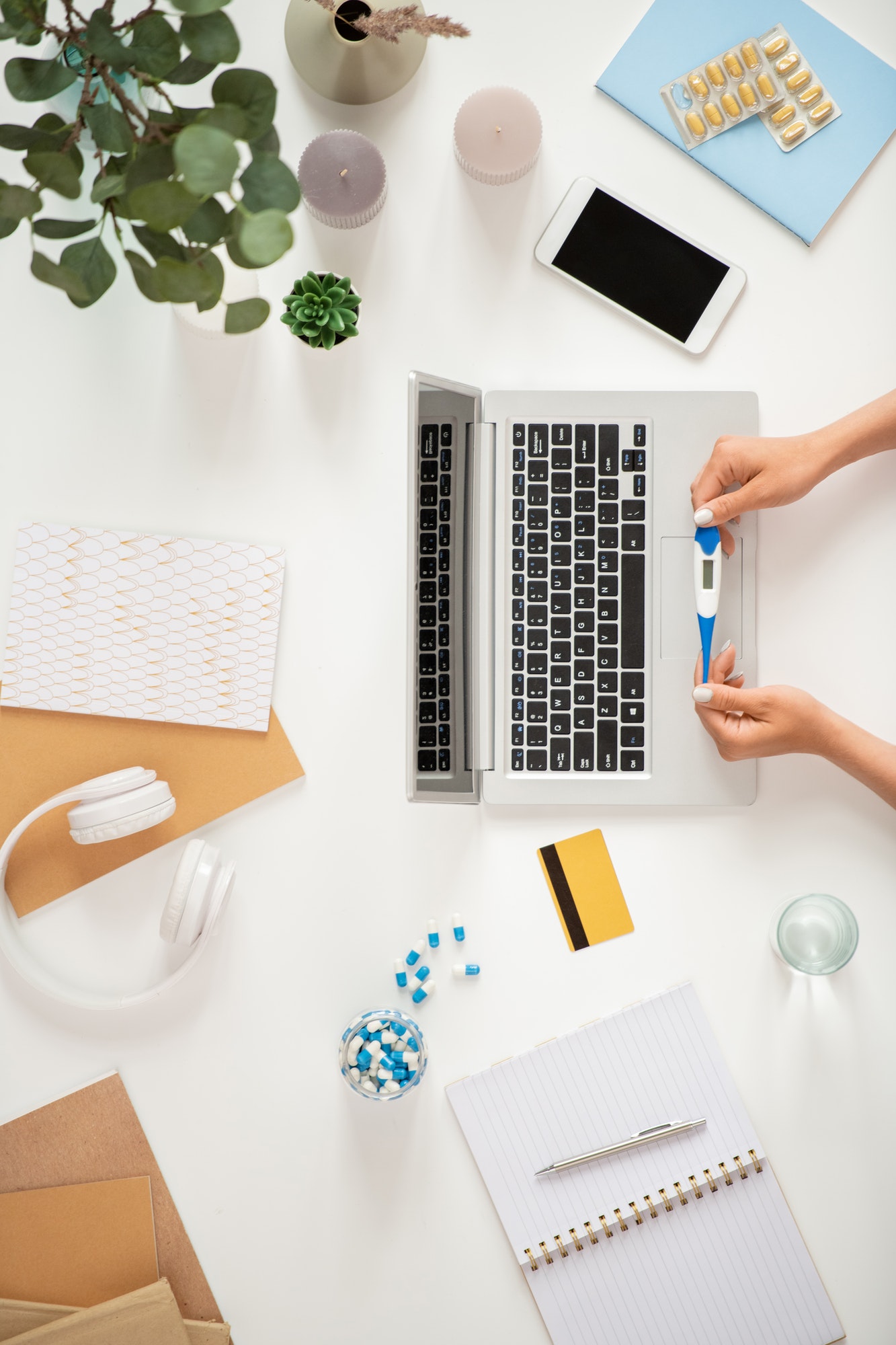 Sick human with thermometer over laptop keypad ordering medicine online